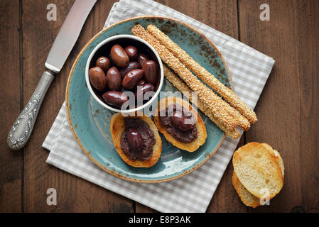 Du pain avec de la pate d'olive sur gros plan de la plaque. La cuisine grecque Banque D'Images