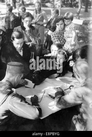 La photo d'un reportage nazi montre les réfugiés allemands de Sudeten qui ont fui la Tchécoslovaquie ont été traités par l'administration allemande après leur arrivée à Augustusburg, en Allemagne, en septembre 1938. Le texte original de la propagande nazie se lit comme suit : « les Allemands des Sudètes fuyant la terreur tchèque. Les femmes et les enfants sont inscrits sur les listes après leur arrivée à Augustusburg (près de Chemnitz). Ils ont ensuite été emmenés dans la maison de récupération d'Augustusburg. Fotoarchiv für Zeitgeschichtee - PAS DE SERVICE DE FIL Banque D'Images