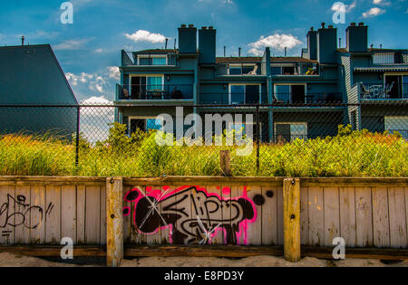 Graffiti sur une clôture en bois en face de fronts d'appartements à Point Pleasant Beach, New Jersey. Banque D'Images