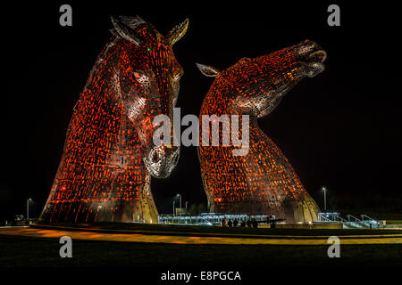 Vue nocturne des sculptures de chevaux Kelpies à Falkirk, en Écosse, au Royaume-Uni. Très grandes statues métalliques de deux têtes de chevaux, éclairage rouge de l'intérieur. Banque D'Images
