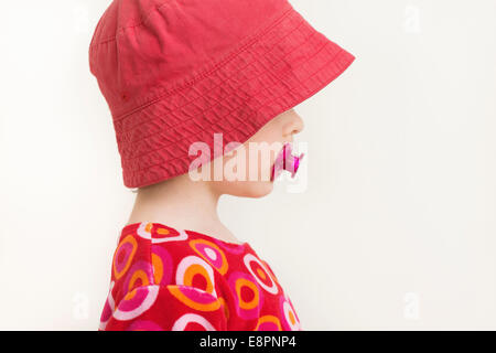 Portrait de profil de petite fille avec Red Hat et suce Banque D'Images