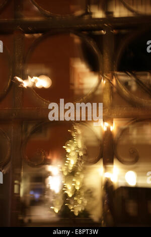 Reflets dans une vitrine. Ville suédoise sur une nuit d'hiver glaciale, floue. Banque D'Images