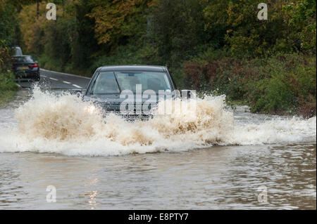 L'Essex, Royaume-Uni. 13 octobre, 2014. La conduite des véhicules par des routes inondées près de Buttsbury dans Essex après une nuit de pluie torrentielle. Credit : Gordon 1928/Alamy Live News Banque D'Images