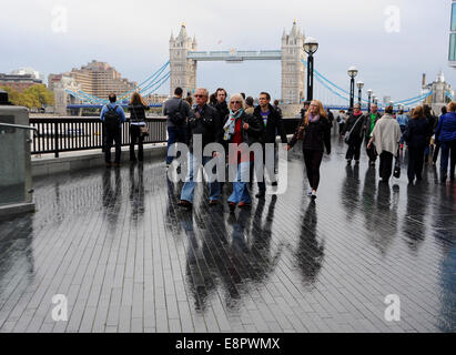 Southwark London UK - Les visiteurs de marcher le long de la rivière près de Tower Bridge Londres sous la pluie UK Banque D'Images