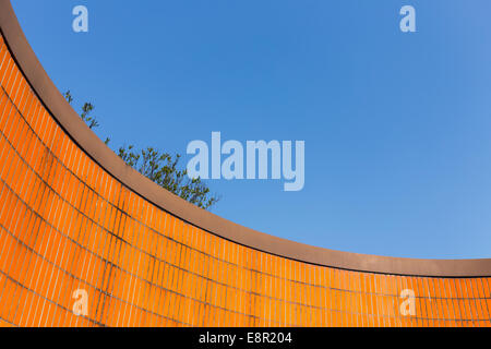 Voir jusqu'à un mur carrelé orange vif contre le ciel bleu profond à Berlin, Allemagne. Banque D'Images