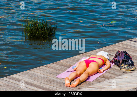 Moscou, Russie. 22 Juillet 2014 : la cuisson au soleil. Une jeune femme méconnaissable non identifiés sur le pont par la rivière de Moscou Banque D'Images