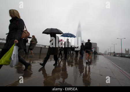 Les gens marcher sur le pont de Londres avec Shard en arrière-plan dans la pluie, le brouillard et la brume Banque D'Images