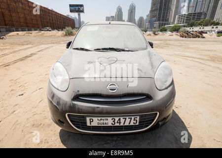 Couverte de sable voiture abandonnée dans un parking voiture à Dubaï Émirats Arabes Unis Banque D'Images