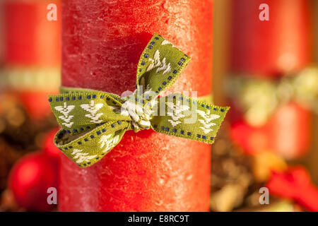 Bougie rouge avec ruban vert sur la guirlande Banque D'Images