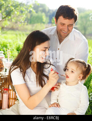 Heureux jeune famille avec bébé fille sur un pique-nique de printemps Banque D'Images