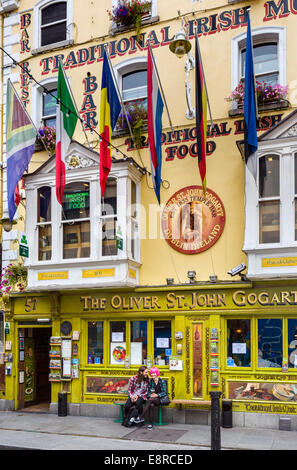 Jeune couple de l'emplacement à l'extérieur de l'Oliver St John pub Half-penny Bridge sur Temple Bar dans le centre-ville, la ville de Dublin, République d'Irlande Banque D'Images