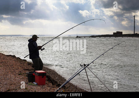 Plage semi silhouette de pêcheur avec flexion de la tige à partir de choc dans ses prises. Banque D'Images