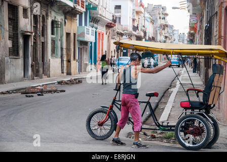 Cuba La Havane - un homme son parking location touristique parmi les débris du bâtiment en ruine de la cabine dans le centre de La Havane street. Banque D'Images