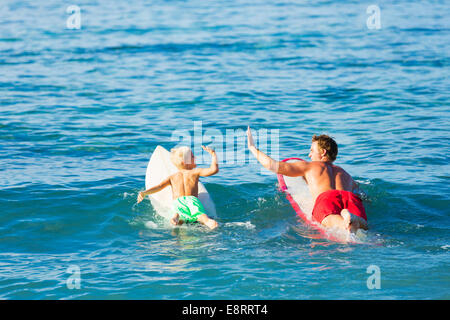 Heureux Père et Fils aller surfer ensemble. Donnant à chaque autre un Hi-Five ! Banque D'Images