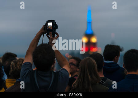 Les touristes prendre des photos de nuit de Manhattan et Empire State Building du Rockefeller Center Observation Deck Banque D'Images