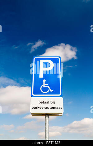 Stationnement pour personnes handicapées Bleu signe pour conducteurs handicapés contre un ciel dramatique Banque D'Images