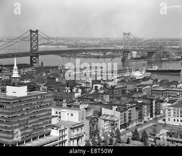 Années 1950, Philadelphie PA USA À AU NORD-EST PASSÉ À BORD DU FLEUVE DELAWARE BENJAMIN FRANKLIN BRIDGE À CAMDEN NJ Banque D'Images