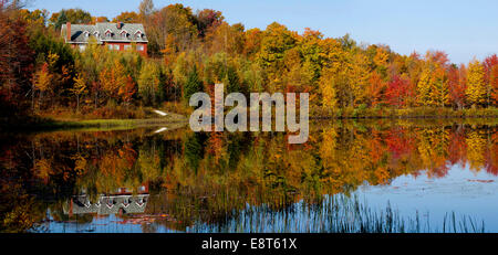 Maison sur étang de castors parmi les arbres en automne, Estrie, West Bolton, Québec, Canada Banque D'Images