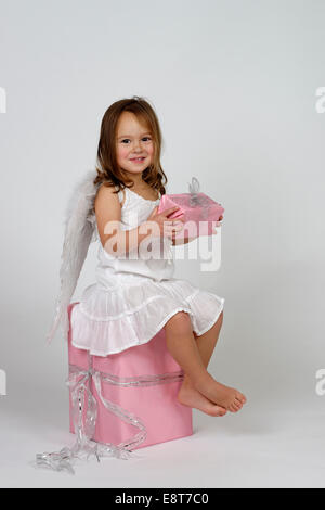 Girl dressed as angel, avec les cadeaux de Noël Banque D'Images