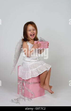 Girl dressed as angel, avec les cadeaux de Noël Banque D'Images