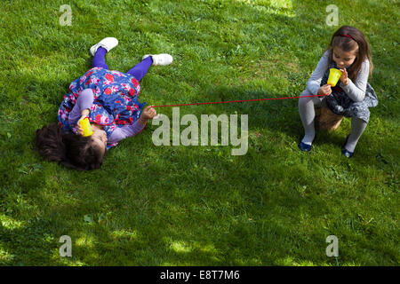 Deux jeunes filles, jouant dans parc avec toy phone Banque D'Images