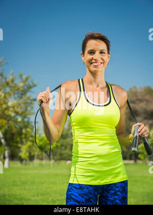 Mixed Race woman holding jump rope in park Banque D'Images
