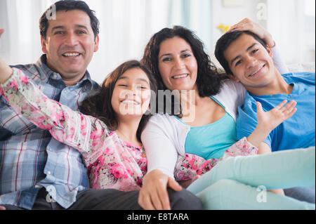 Hispanic family smiling together on sofa Banque D'Images