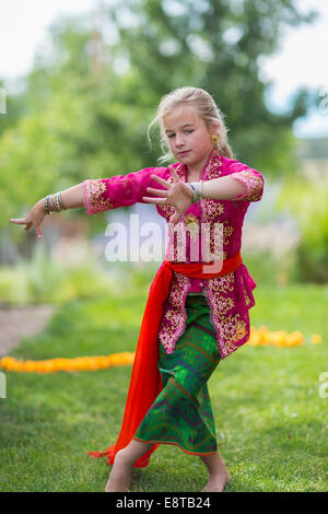 Woman performing danse balinaise in backyard Banque D'Images