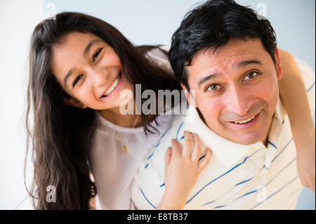 Hispanic father carrying daughter piggyback Banque D'Images