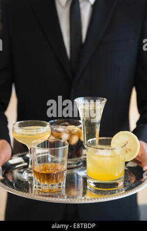 Close up of mixed race waiter holding tray de boissons Banque D'Images