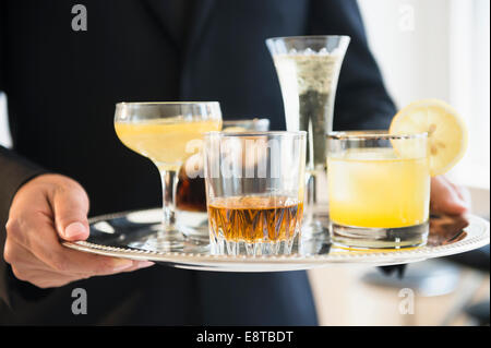 Close up of mixed race waiter holding tray de boissons Banque D'Images