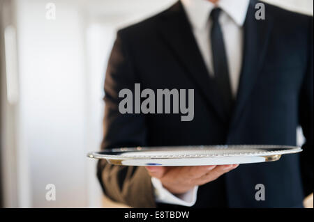 Close up of mixed race waiter holding bac vide Banque D'Images