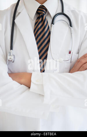 Close up of mixed race doctor with arms crossed Banque D'Images