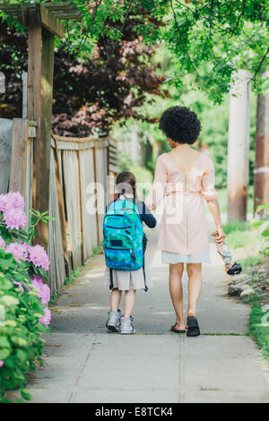 Mixed Race mother and daughter sur trottoir de banlieue Banque D'Images