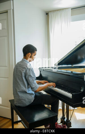 Mixed Race boy playing piano Banque D'Images