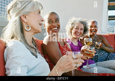 Les femmes boire du vin ensemble on urban rooftop Banque D'Images