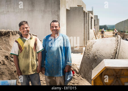 Hispanic construction workers smiling at construction site Banque D'Images