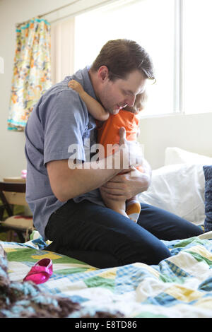 Young Girl holding daughter on bed Banque D'Images