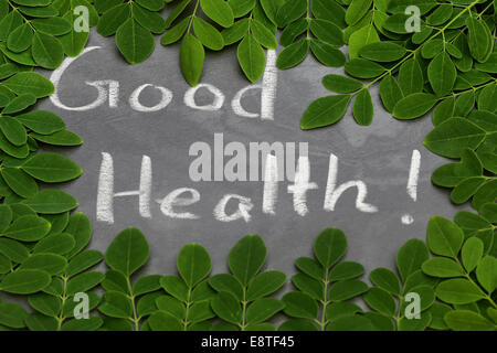 Les feuilles de Moringa avec bonne santé écrit dans un ordre en craie whtie Banque D'Images