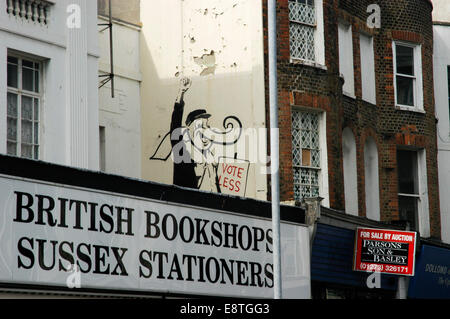 L'artiste graffiti banksy art peint à la bombe sur le côté des bâtiments et magasins à Brighton Banque D'Images