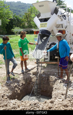 Les hommes birmans travaillant la coulée du ciment, pour un mur en Thaïlande Banque D'Images