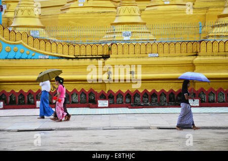 Birmans marcher lorsqu'il pleut à la Pagode Shwemawdaw paya un stupa est le 13 juillet 2014 à Bago, Birmanie. Banque D'Images