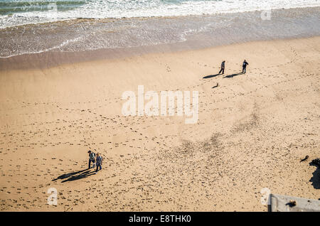 Deux couples et un chien marche sur North beach à Tenby UK Banque D'Images