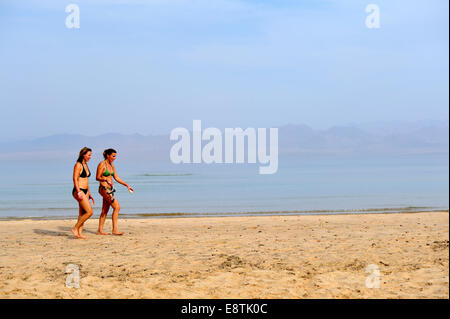 Deux femmes marchant le long de la plage de sable au bord de mer Banque D'Images