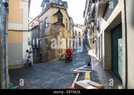 Scène de rue dans l'Alfama avec l'homme en scooter et deux enfants, Lisbonne, Portugal Banque D'Images