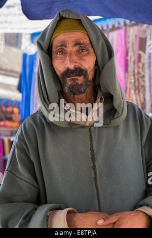 Un berbère traditionnel, qui demande des almes à l'extérieur d'un café le long de l'une des nombreuses rues latérales du souk d'Essaouira. Maroc. Banque D'Images