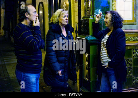 Trois personnes se tiennent à l'extérieur pour une cigarette à un pub anglais traditionnel l'Eldon arms uk angleterre southsea Banque D'Images