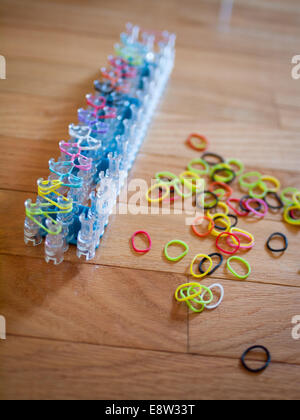 Un arc-en-ciel coloré et tisser des bandes de caoutchouc. Rainbow loom est une gaine de plastique utilisé pour tisser des bandes de caoutchouc en bracelets et charms. Banque D'Images