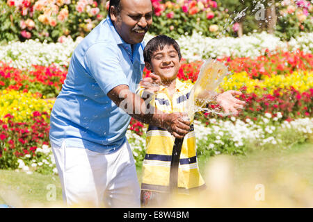 1 Indien pulvériser de l'eau avec kid Banque D'Images