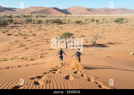 Deux adolescents sur une dune, Sossusvlei, Désert du Namib, Namibie Banque D'Images